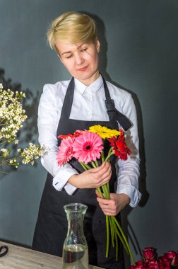 Çiçekçide çalışan genç bir kadın çiçekçi.