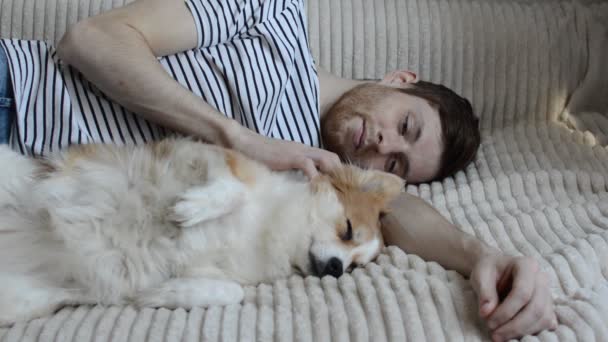 Jonge Man Ligt Een Bed Met Zijn Slapende Hond — Stockvideo