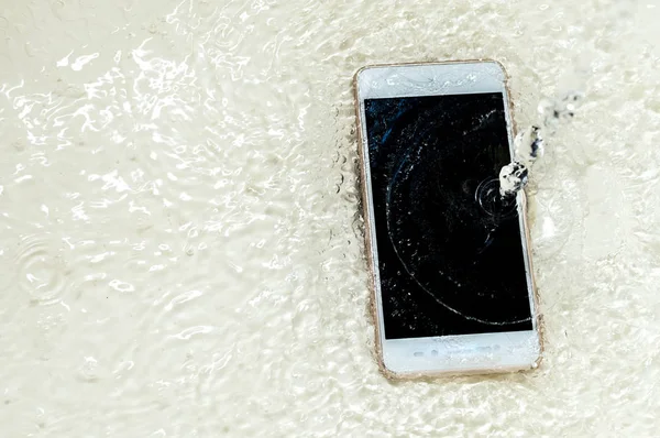 Teléfono en el agua de cerca. Concepto de teléfono roto. Copiar espacio — Foto de Stock