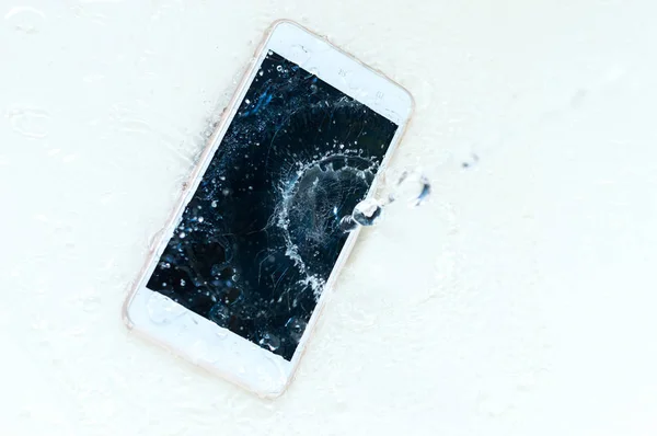 El teléfono cayó al agua. Teléfono y spra de agua — Foto de Stock