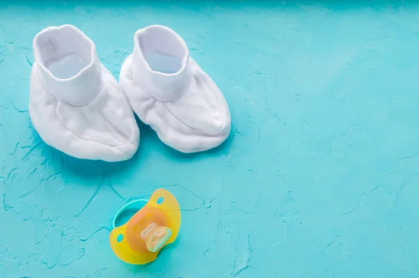 Concepto de recién nacido. Calcetines y pezón, sobre fondo azul. Puesta plana — Foto de Stock