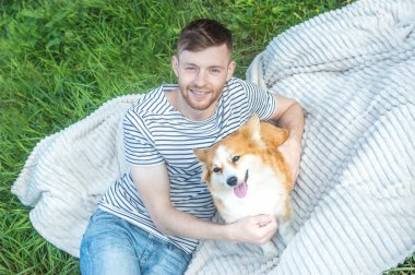 Köpeğiyle mutlu gülümseyen sahibi çimenlerin üzerinde yatıyor