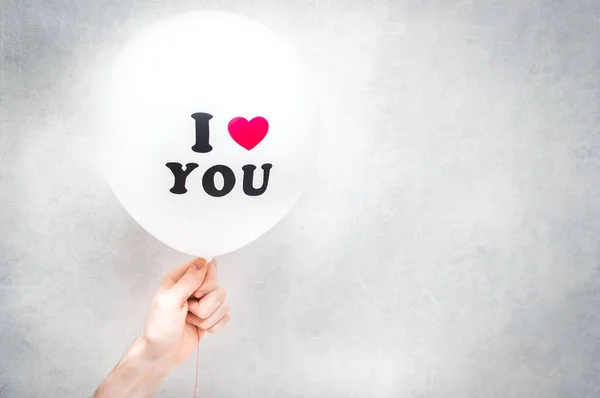 Inscripción Te amo en un globo blanco en la mano de un hombre. Día de San Valentín — Foto de Stock
