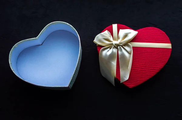 Otwarte pudełko w kształcie serca z kokardą na czarnym tle. Romantyczny pomysł na prezent. Walentynki — Zdjęcie stockowe