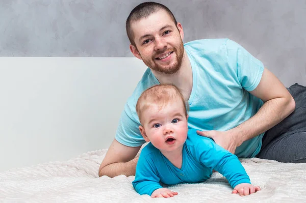 Retrato Joven Padre Sonriente Con Bebé Ropa Azul Cama Abrazo — Foto de Stock