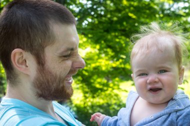 Baba ve küçük gülümseyen çocuğun yakın plan portresi.