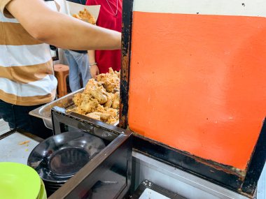 Bir garson Endonezya 'nın popüler büfe yemekleri Warung Nasi Padang' da bir sipariş hazırlar..