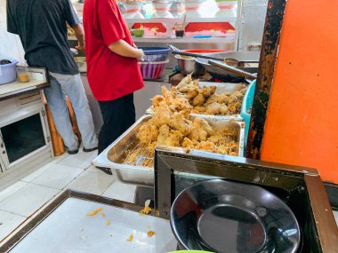 Bir garson Endonezya 'nın popüler büfe yemekleri Warung Nasi Padang' da bir sipariş hazırlar..
