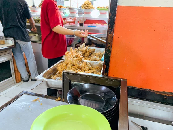 Bir garson Endonezya 'nın popüler büfe yemekleri Warung Nasi Padang' da bir sipariş hazırlar..