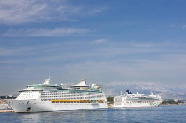 SPLIT, CROATIA, 08.15.2020: Cruise ships anchored near a picturesque coastal city with scenic views and a vibrant skyline, under a clear blue sky and tranquil seas.