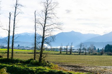 Kanada 'nın Abbotsford' dan Umut 'a uzanan kırsal Kanada manzarası. Arka planda dağlar, vadiler ve çiftlikler var.