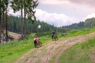 Dağlarda bisiklete binen adam ve kız