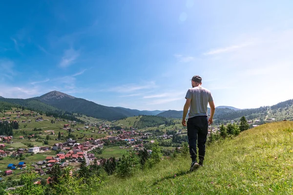 Adam dağdan dağlardaki köye bakar.