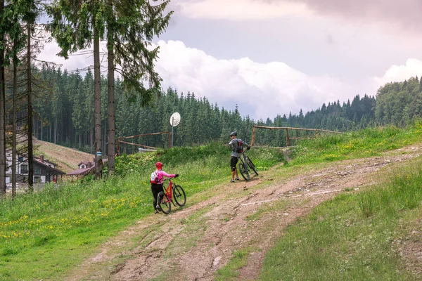 Dağlarda bisiklete binen adam ve kız