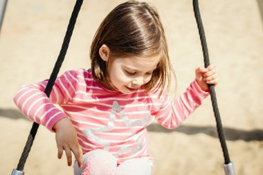 güzel küçük bir kız bir yaz gününde Bahçesi adlı bir salıncak üzerinde sallanıyor