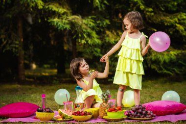iki küçük kız kardeş balonlu yaz ormanda piknik yapmaya çalışıyorsun