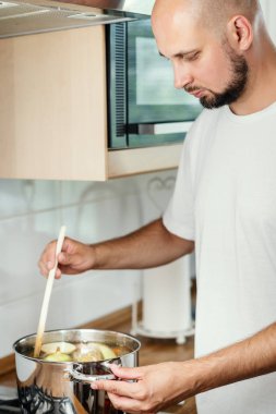 adam lezzetli ve güzel kokulu suyu bir tencerede mutfakta Soba gaz karışımları