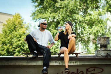 kaykay çocuk ve oturan kız ve içme suyu bir yaz gününde