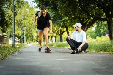 Kız paten öğrenir ve çocuk onun tavsiyelerini bir yaz günü verir.