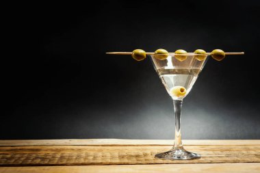 lezzetli martini içmek bir cam ahşap bir masa üzerinde bir çubuk üzerinde zeytinli