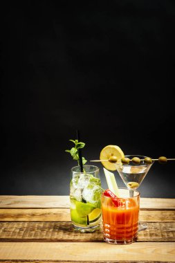 zeytin ve nane ile mojito ve kereviz ahşap bir masa üzerinde kanlı mary ile lezzetli martini içki