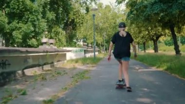 kız bir yaz park Caddesi üzerinde bir kaykay sürmek