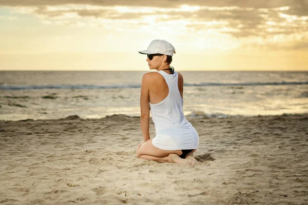 Hermosa Mujer Camisa Gorra Blanca Sentada Playa Atardecer —  Fotos de Stock