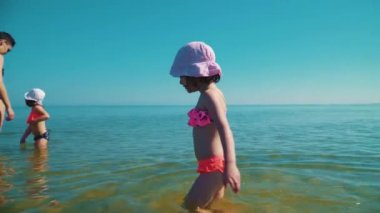 Genç Anne ve iki sevimli kızı denizde ayakta ve kendilerini zevk