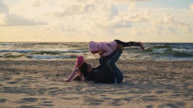 Anne ve iki kızı yaz aylarında günbatımı kum plaj üzerinde yapmaya çalışıyorsun