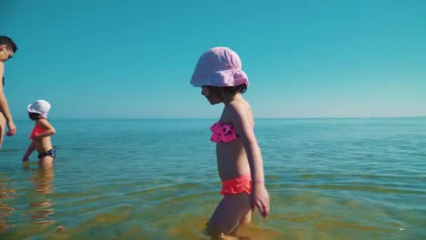 若い母親と 人のかわいい娘を海に立って 自分自身を楽しんで — ストック動画