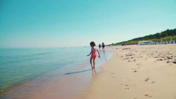 两个可爱的女孩在海边的沙滩上奔跑 — 图库视频影像