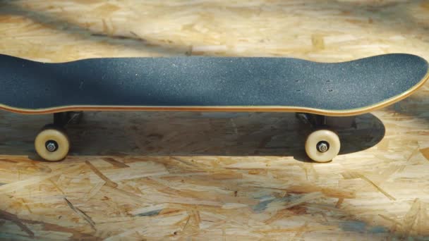 Skateboard με λευκό τροχούς σε ένα ξύλινο υπόβαθρο σε ένα skatepark — Αρχείο Βίντεο