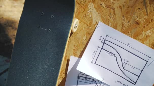 Skateboard op een houten achtergrond met plannen voor een miniramp in een skatepark — Stockvideo