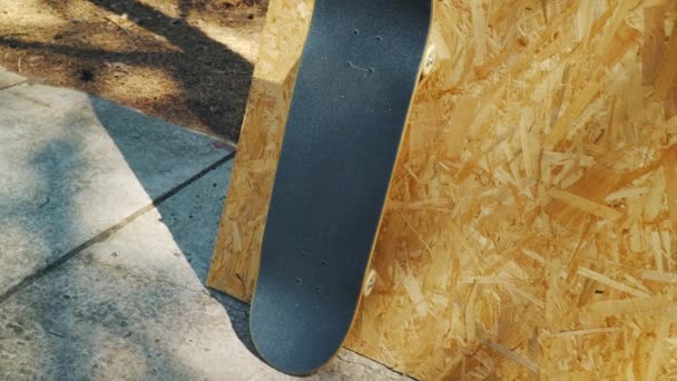 Skateboard με λευκό τροχούς σε ένα ξύλινο υπόβαθρο σε ένα skatepark — Αρχείο Βίντεο