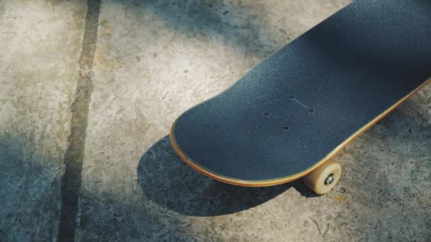 Monopatín sobre un fondo de hormigón en un skatepark en el verano — Vídeos de Stock