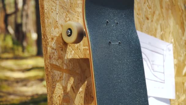 Skateboard auf hölzernem Hintergrund mit Plänen für eine Minirampe in einem Skatepark — Stockvideo