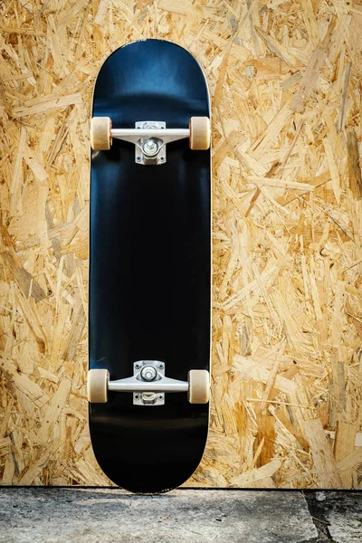Skateboard s bílými koly na dřevěné pozadí v skatepark — Stock fotografie