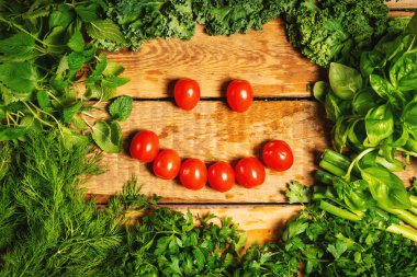 yeşil sebze ve bir gülümseme ile ahşap bir masa üzerinde domates