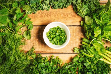 yeşil sebze ve ahşap bir masa üzerinde kase içinde baharatlar