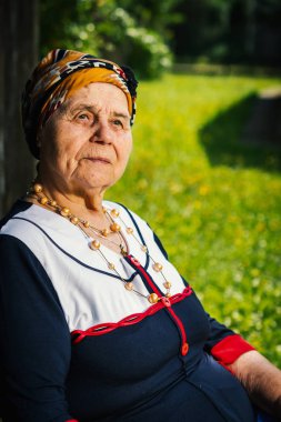 Yaşlı kadın bir tezgah ve bir fotoğraf için poz oturuyor