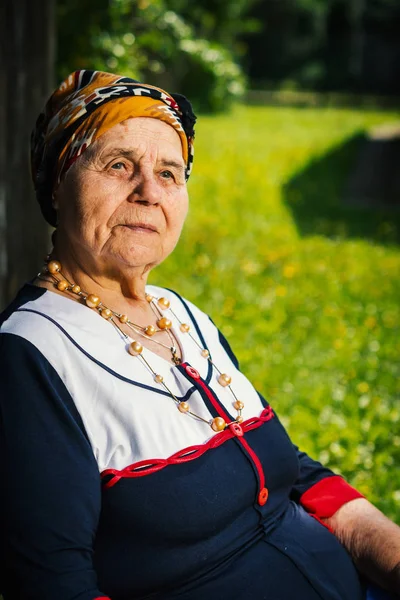 Yaşlı kadın bir tezgah ve bir fotoğraf için poz oturuyor — Stok fotoğraf