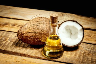 Hindistan cevizi ve bir şişe siyah bir zemin üzerine ahşap bir masa üzeri yağlıboya