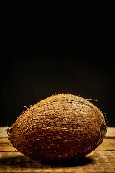 Cocco fresco su tavolo di legno su sfondo nero — Foto Stock