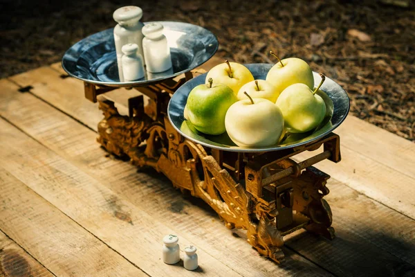 Oude weegschalen geschilderd goud met gewichten en groene appels — Stockfoto