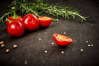 taze ve baharatlı kırmızı biber ve biberiye siyah ahşap bir masa üzerinde