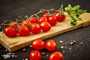 lezzetli ve sulu domates ve fesleğen siyah bir tabloda bir ahşap tahta üzerinde