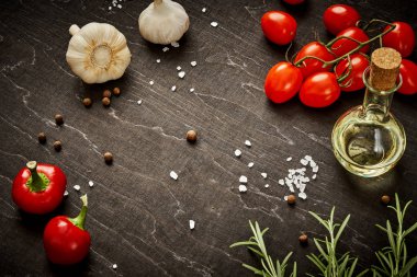 Siyah ahşap masa dökülen tuz ve sebze ve zeytin yağı ile