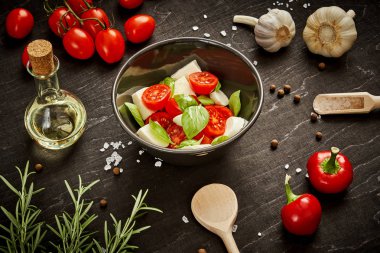 kiraz domates mozzarella ve fesleğen siyah ahşap bir masa üzerinde bir kase ile lezzetli salata