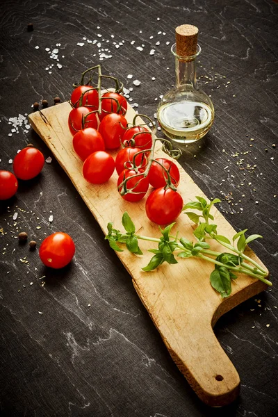 lezzetli ve sulu domates ve fesleğen siyah bir tabloda bir ahşap tahta üzerinde