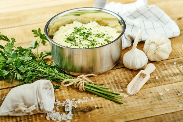 lezzetli ve kremalı taze patates püresi ahşap bir masa üzerinde gümüş bir tencerede maydanoz serpilir